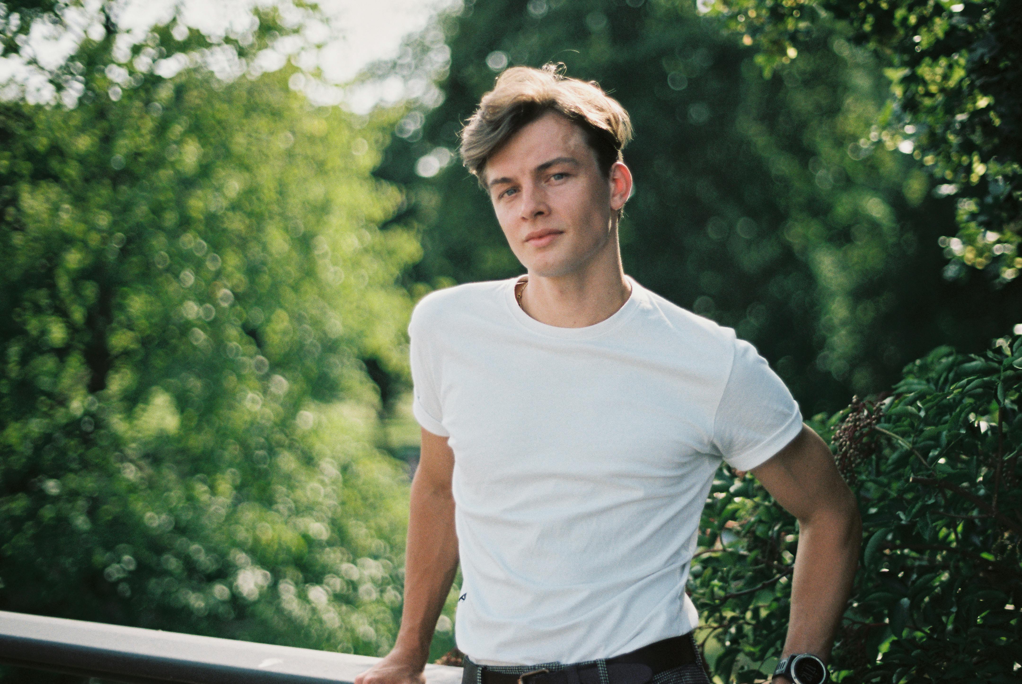 a young man in a white t shirt and black pants