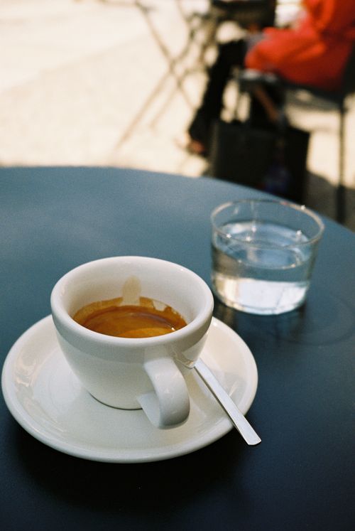 Free A cup of espresso on a table with glass at outdoor cafe. Stock Photo