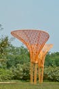 A sculpture made of orange wood in a park