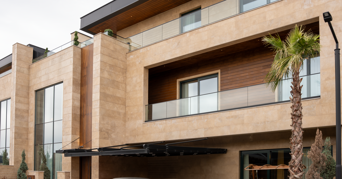 Exterior view of a modern luxury building with vintage cars parked under a sleek balcony.