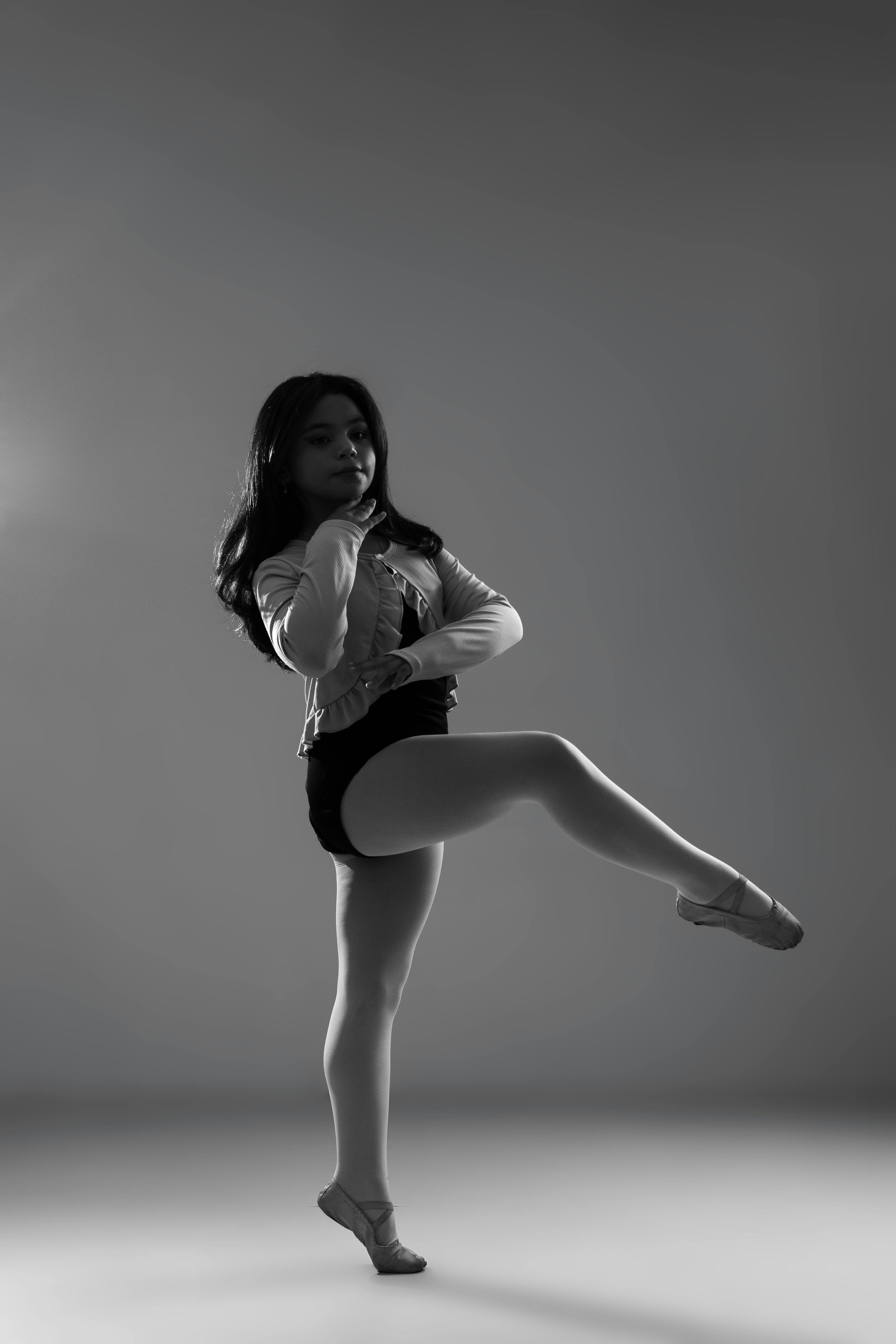 a black and white photo of a girl doing a dance