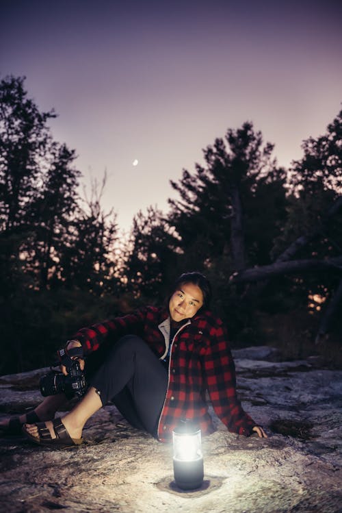 Free Woman Wearing Black and Red Plaid Jacket in Front of Lamp Stock Photo