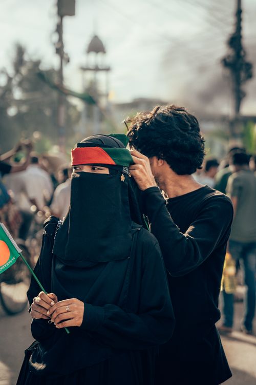 Free A woman in a niqab holding a flag during a street rally in Cumilla, Bangladesh. Stock Photo