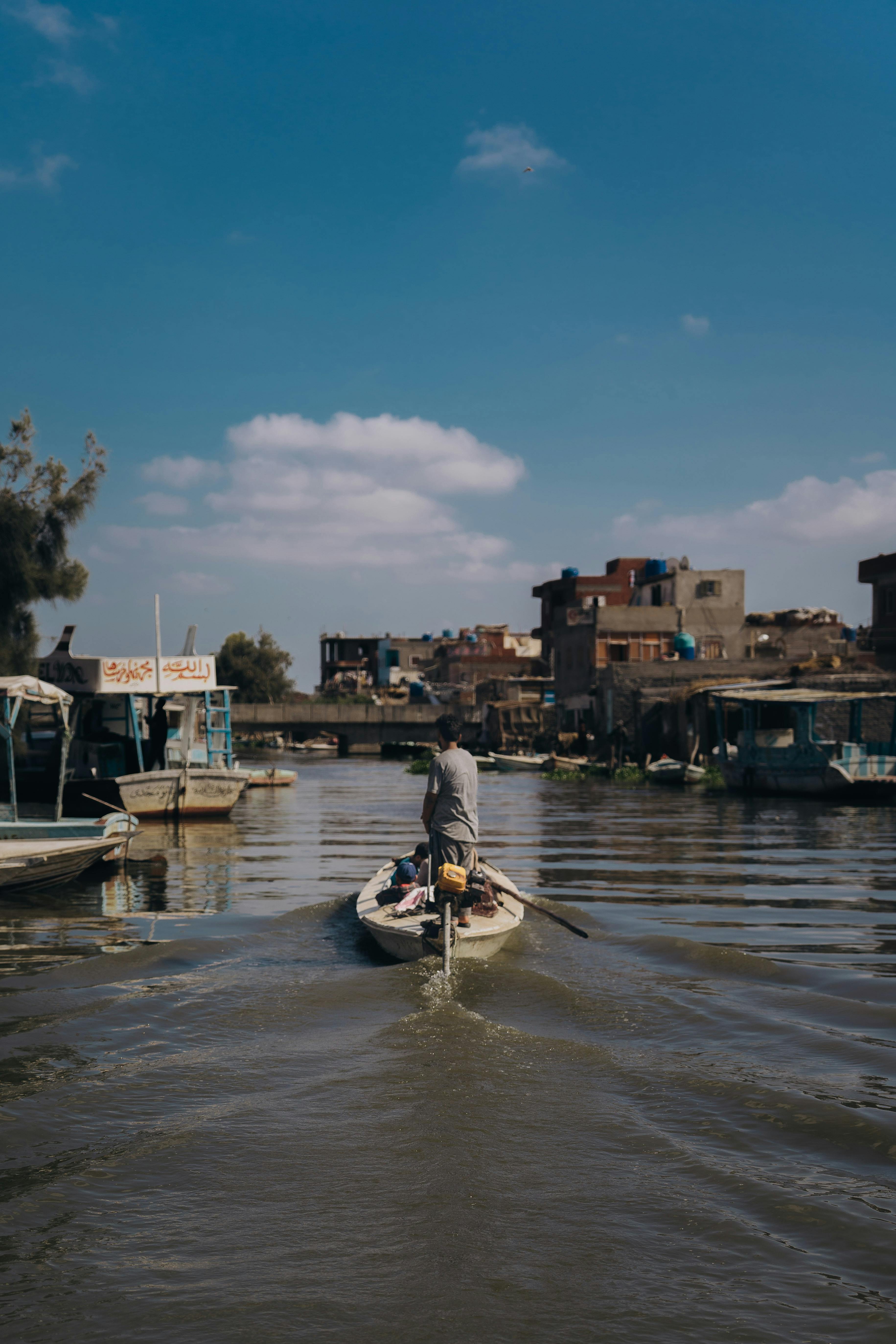 A lone fisherman rows through Cairo's bustling canals, capturing daily life in Egypt.