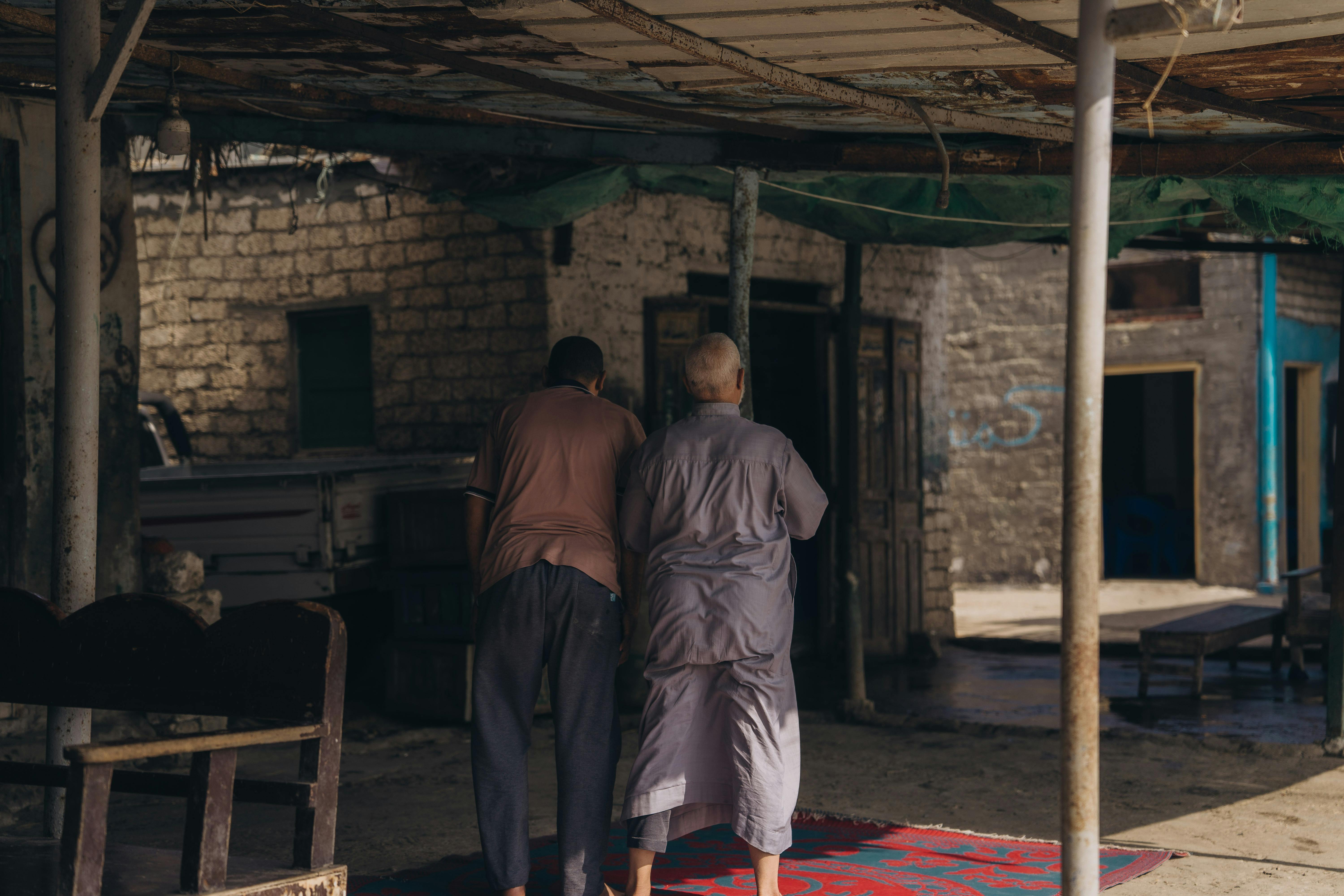 Two men walking in a rustic outdoor setting in Cairo, Egypt.