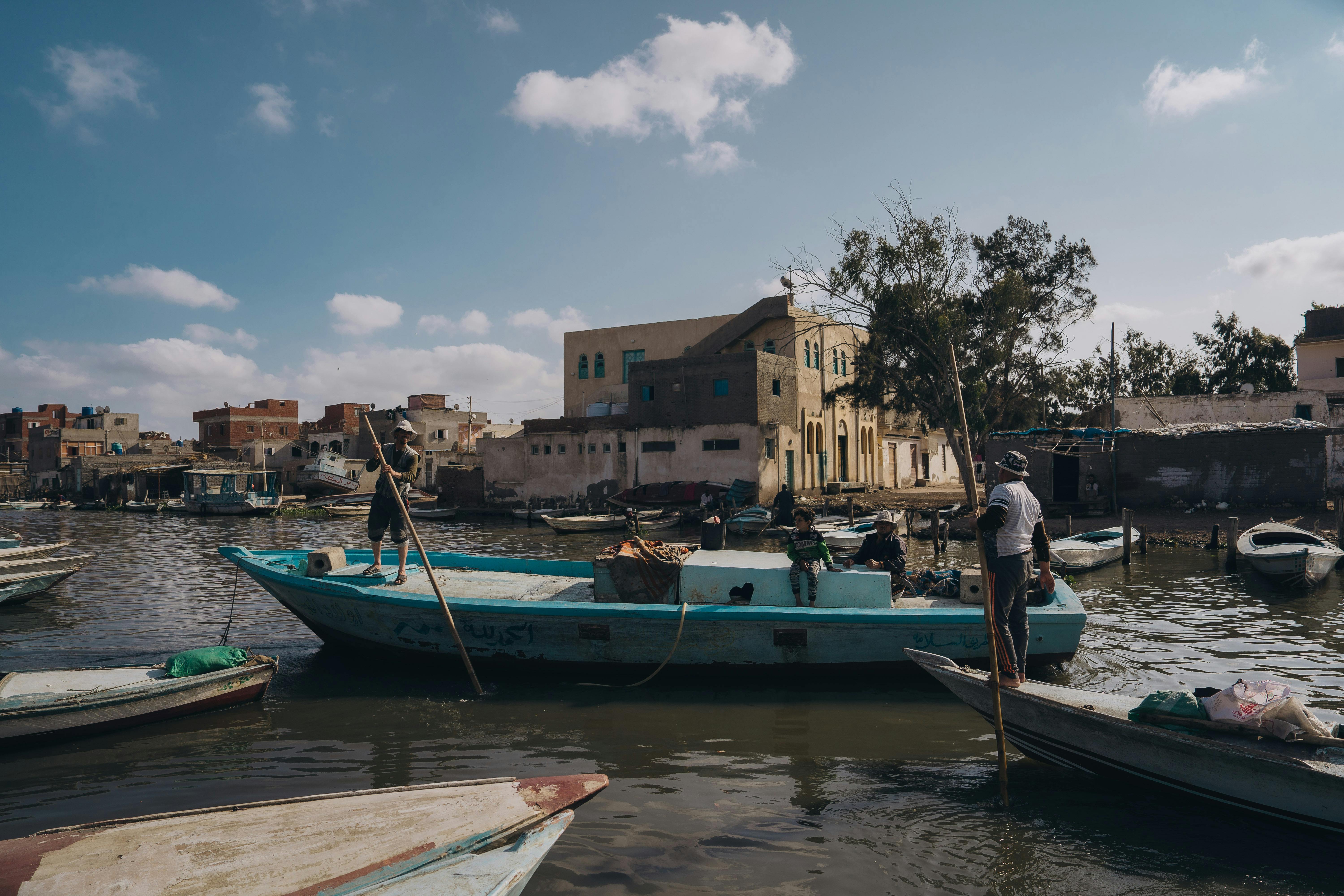 Fishermen navigate the Nile River in Cairo with traditional boats, showcasing local culture.