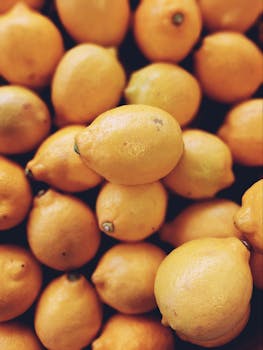 Vibrant close-up shot of a pile of fresh lemons, perfect for food and lifestyle themes.