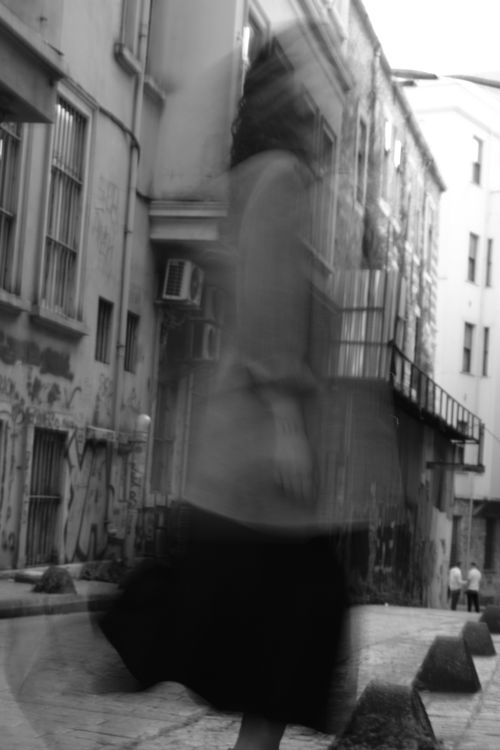 Free Black and white photo of a woman blurring by in a narrow Istanbul alleyway. Stock Photo