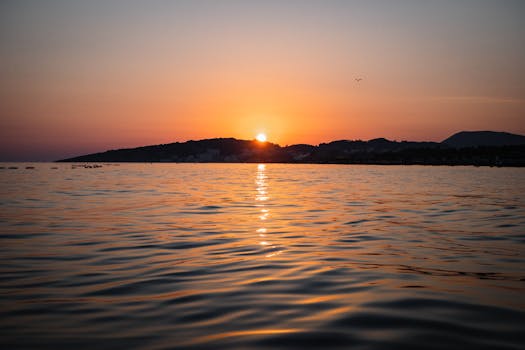 Capture of a serene sunset over Ulcinj beach, Montenegro, reflecting vibrant colors on the water.
