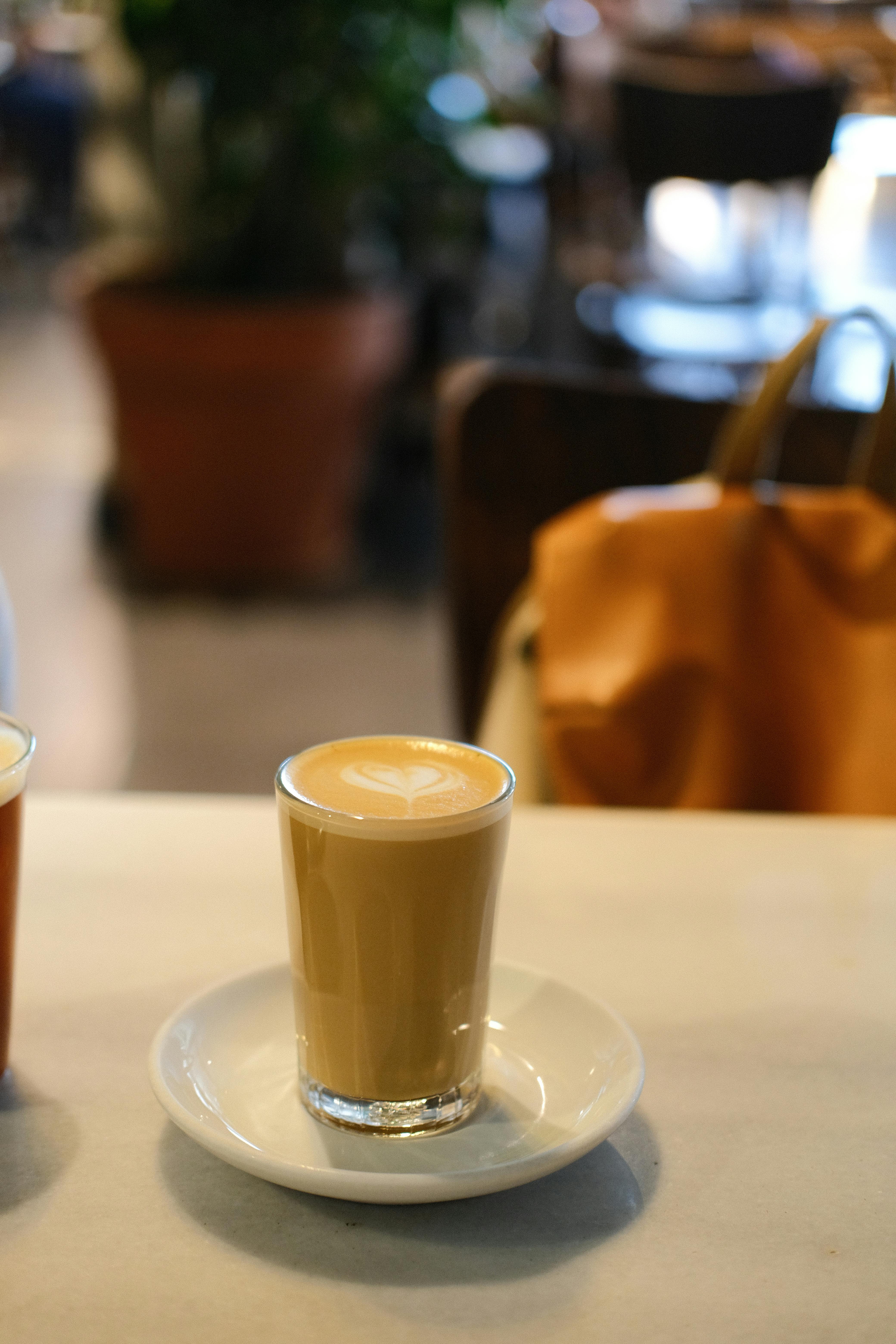 two cups of coffee on a table next to a purse