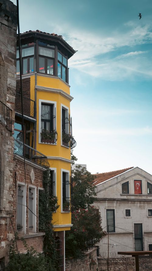 Free Historic Istanbul street featuring a vibrant yellow building with traditional architecture against a clear sky. Stock Photo