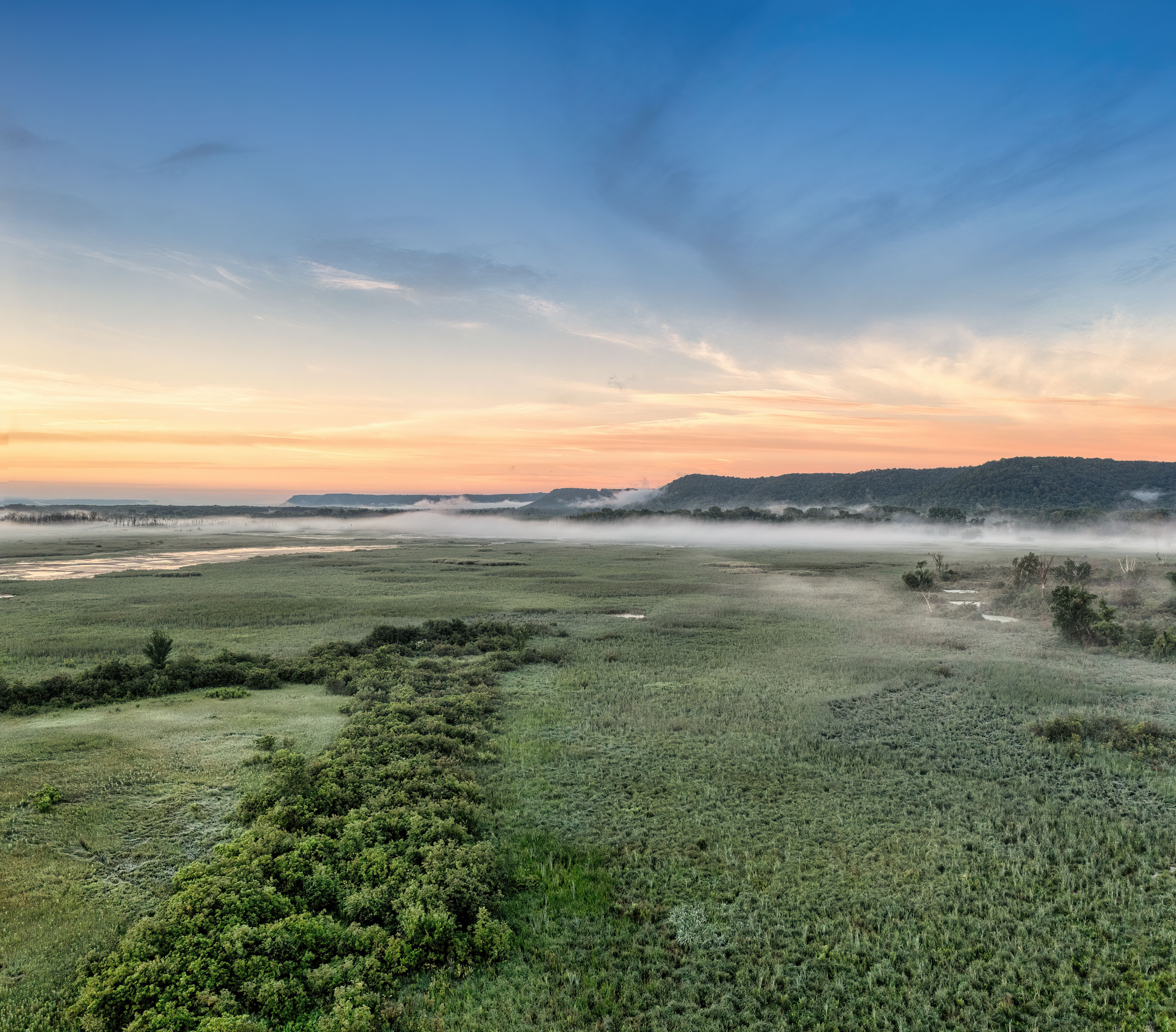 A sunrise over a marshy field with fog · Free Stock Photo