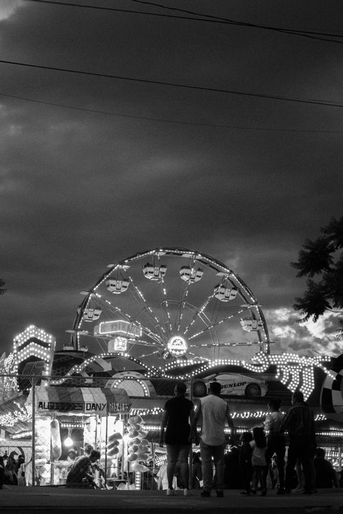 Free A bustling nighttime scene at a carnival in León, México, featuring a brightly lit Ferris wheel. Stock Photo