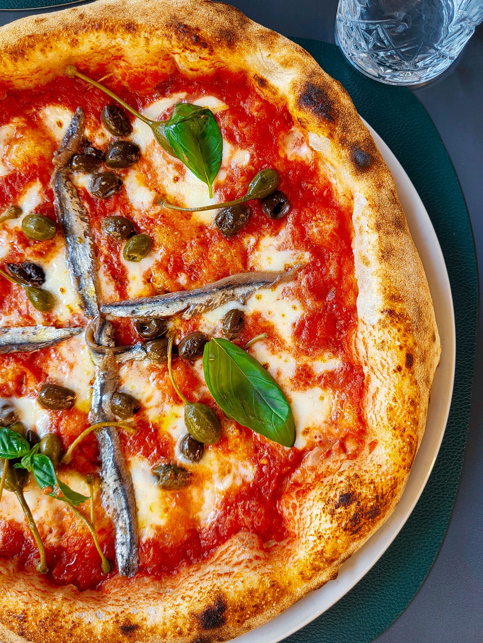 Pizza al pomodoro con acciughe, olive e capperi, fotografia d'archivio.