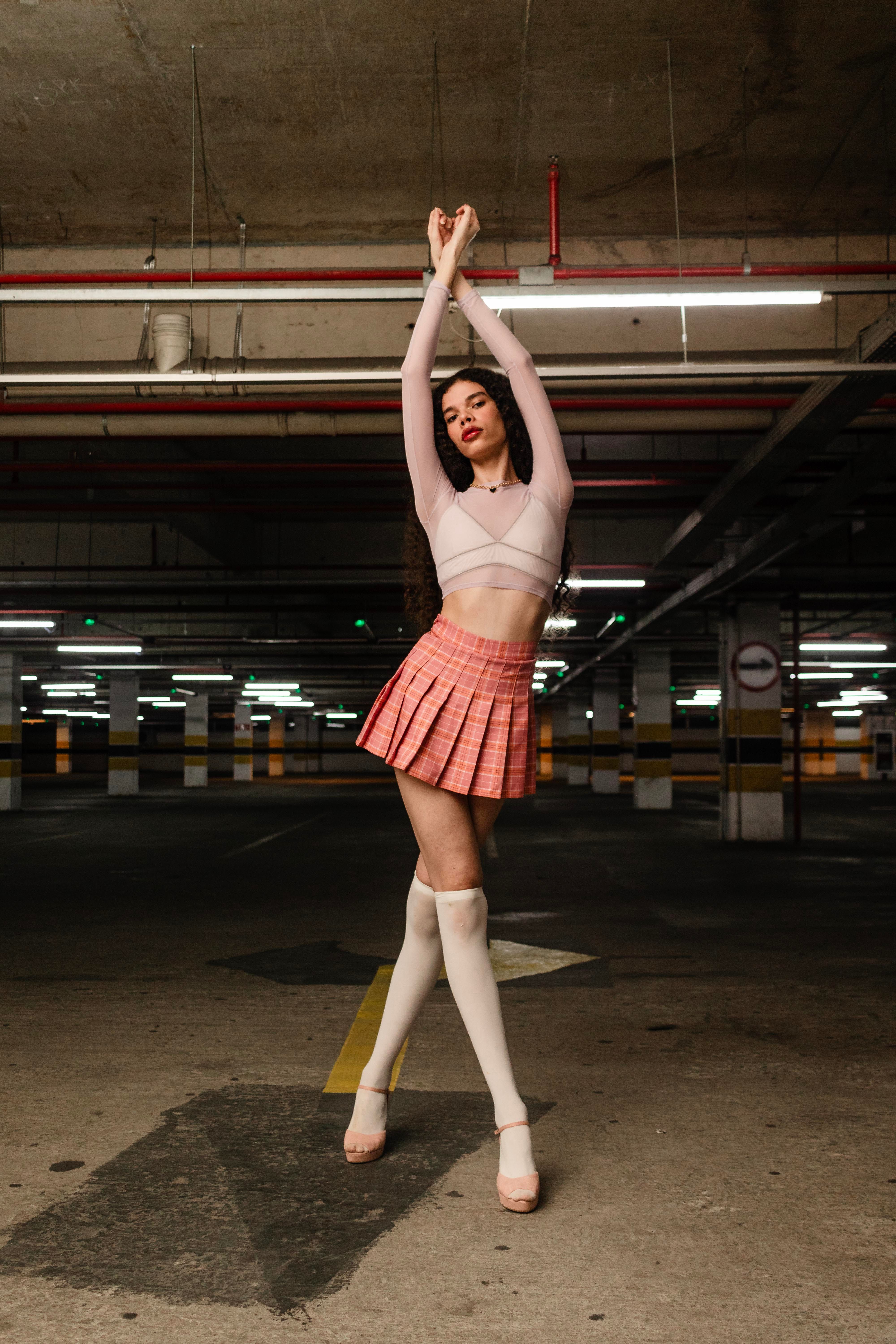 A woman in a pink skirt and white top is posing · Free Stock Photo