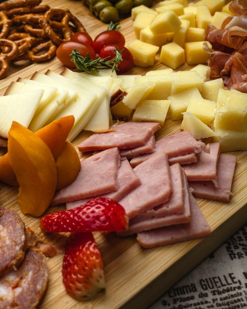 Free A delicious cheese and charcuterie board with fresh fruits and pretzels, perfect for gourmet gatherings. Stock Photo