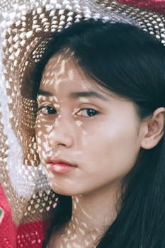 一位年轻女子的肖像，脸上带着艺术感的阴影图案，造型神秘而迷人