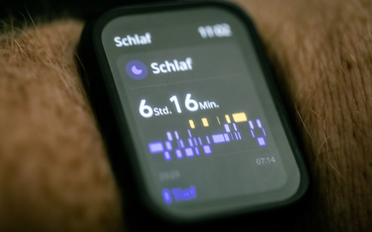 Close-up of a smartwatch displaying sleep tracking data in German.