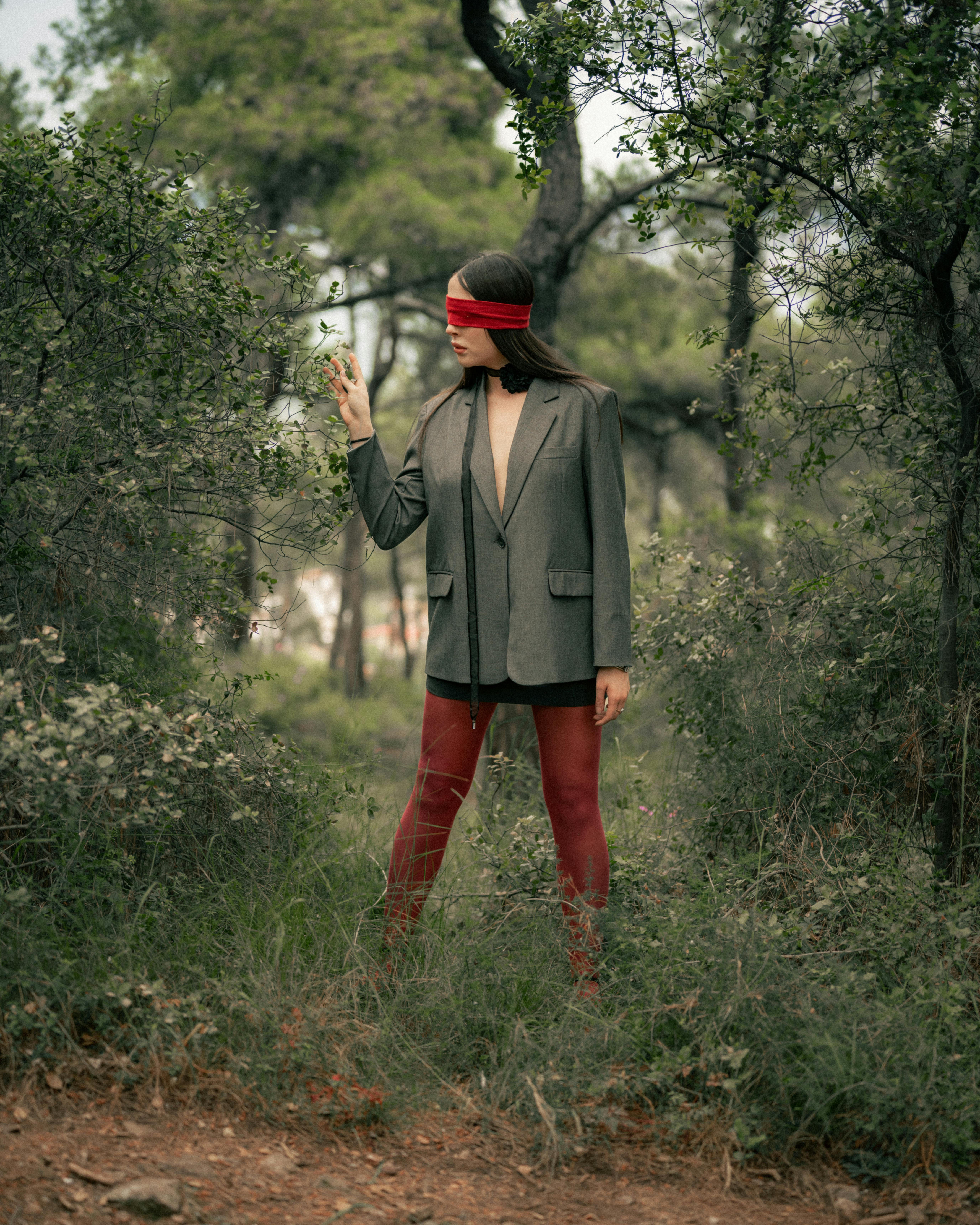 blindfolded woman feeling a shrub