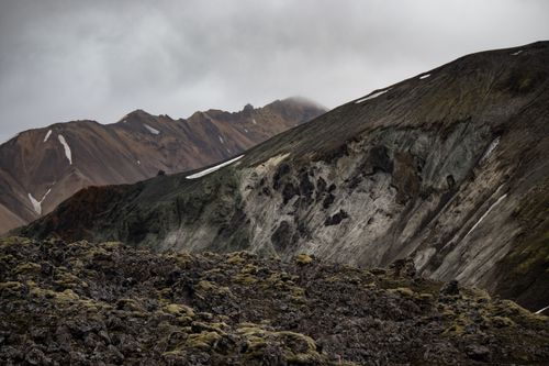 Free Scenic view of rugged Icelandic mountains with dramatic clouds and mossy terrain. Stock Photo