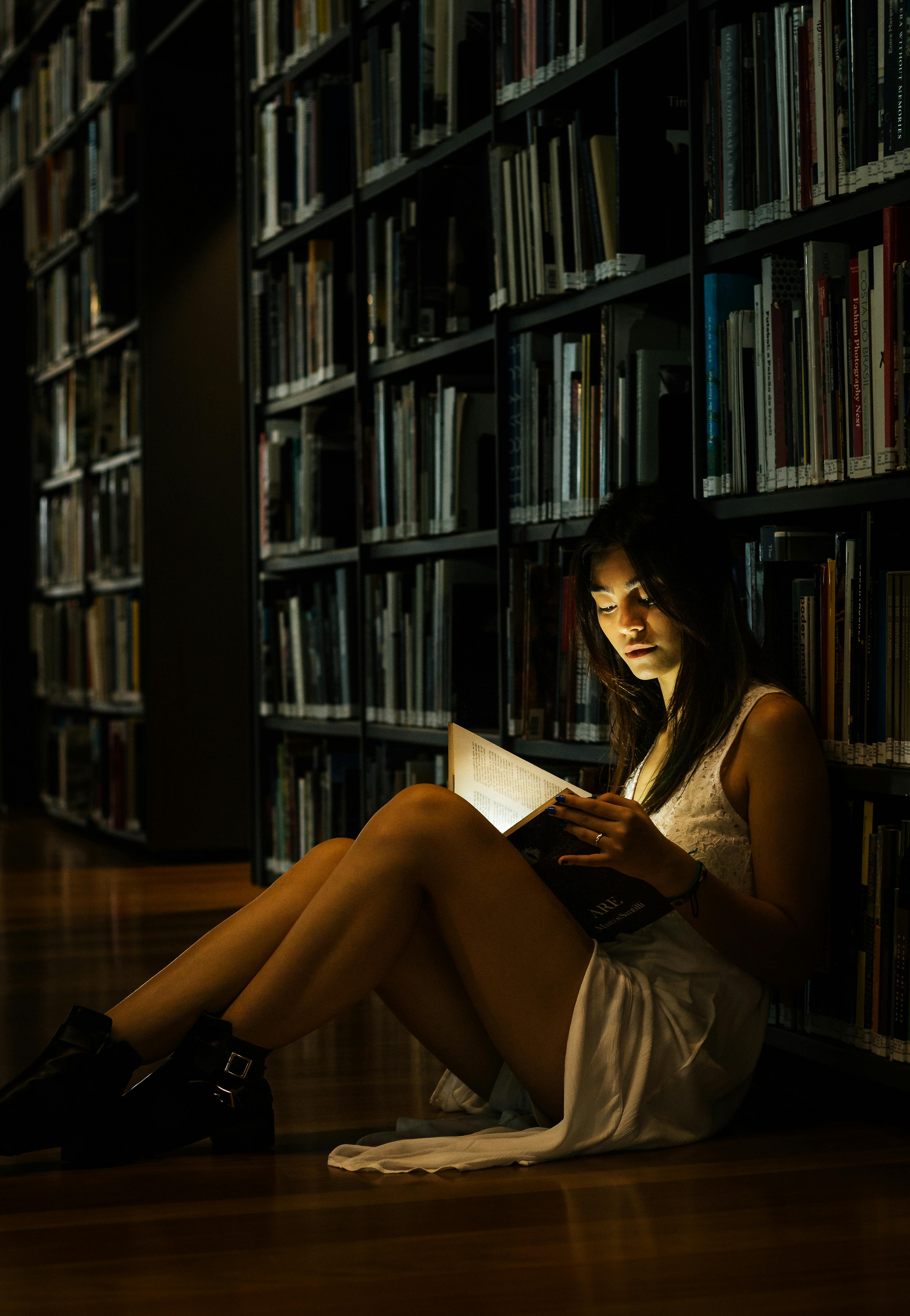 Woman Leaning On Bookshelf · Free Stock Photo