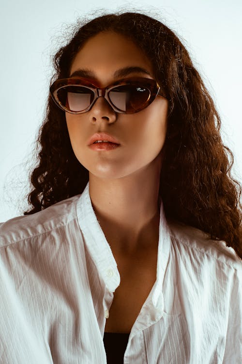 Portrait Photo of Woman in Sunglasses Posing In Front of White Background