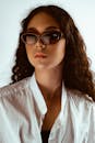 一位戴着太阳镜、穿着白衬衫的卷发女人的肖像