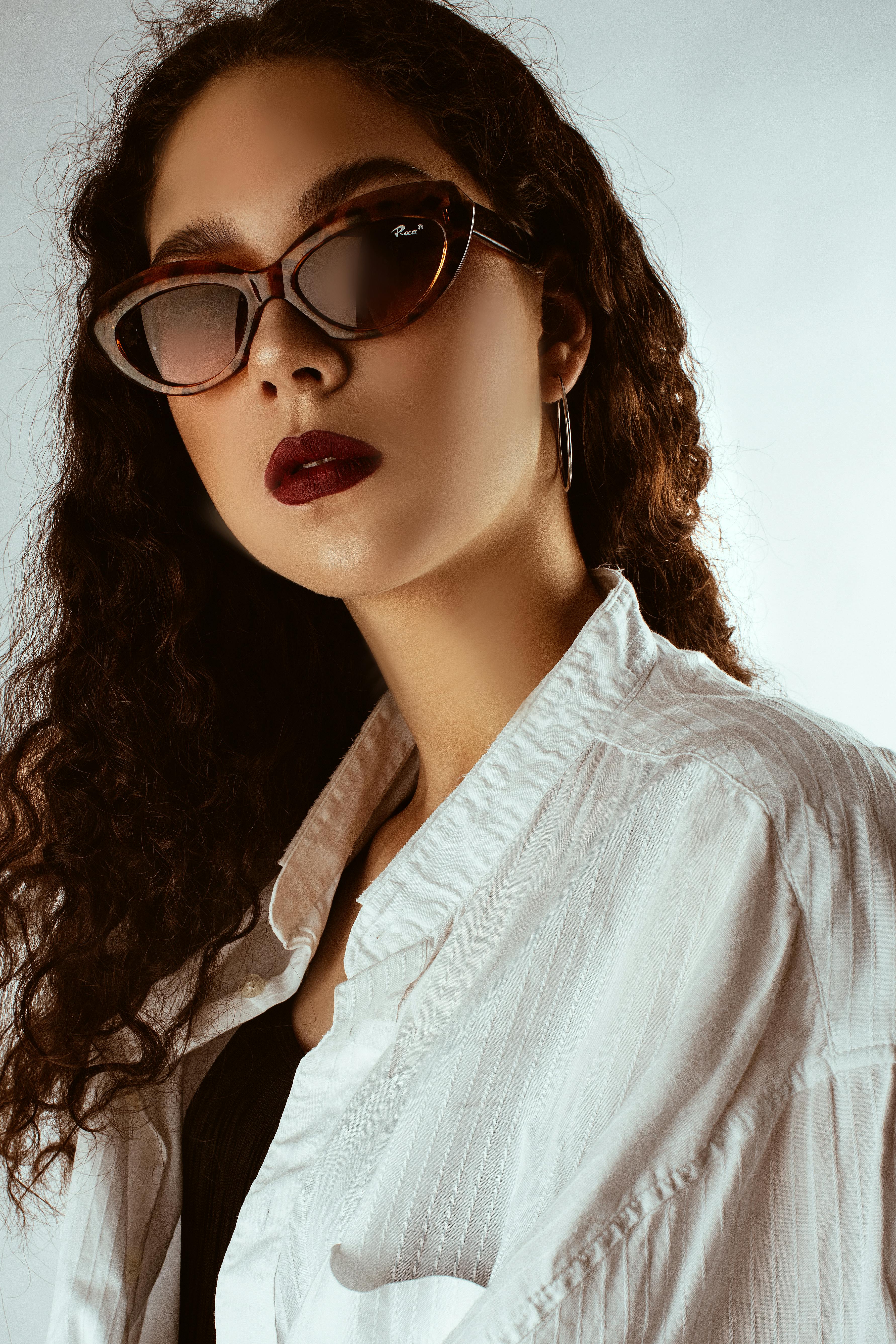 一位戴着太阳镜、涂着红色口红、卷发的时尚女性肖像