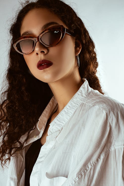 Foto Retrato De Mujer Con Gafas De Sol Y Lápiz Labial Rojo Posando Delante De Un Fondo Blanco