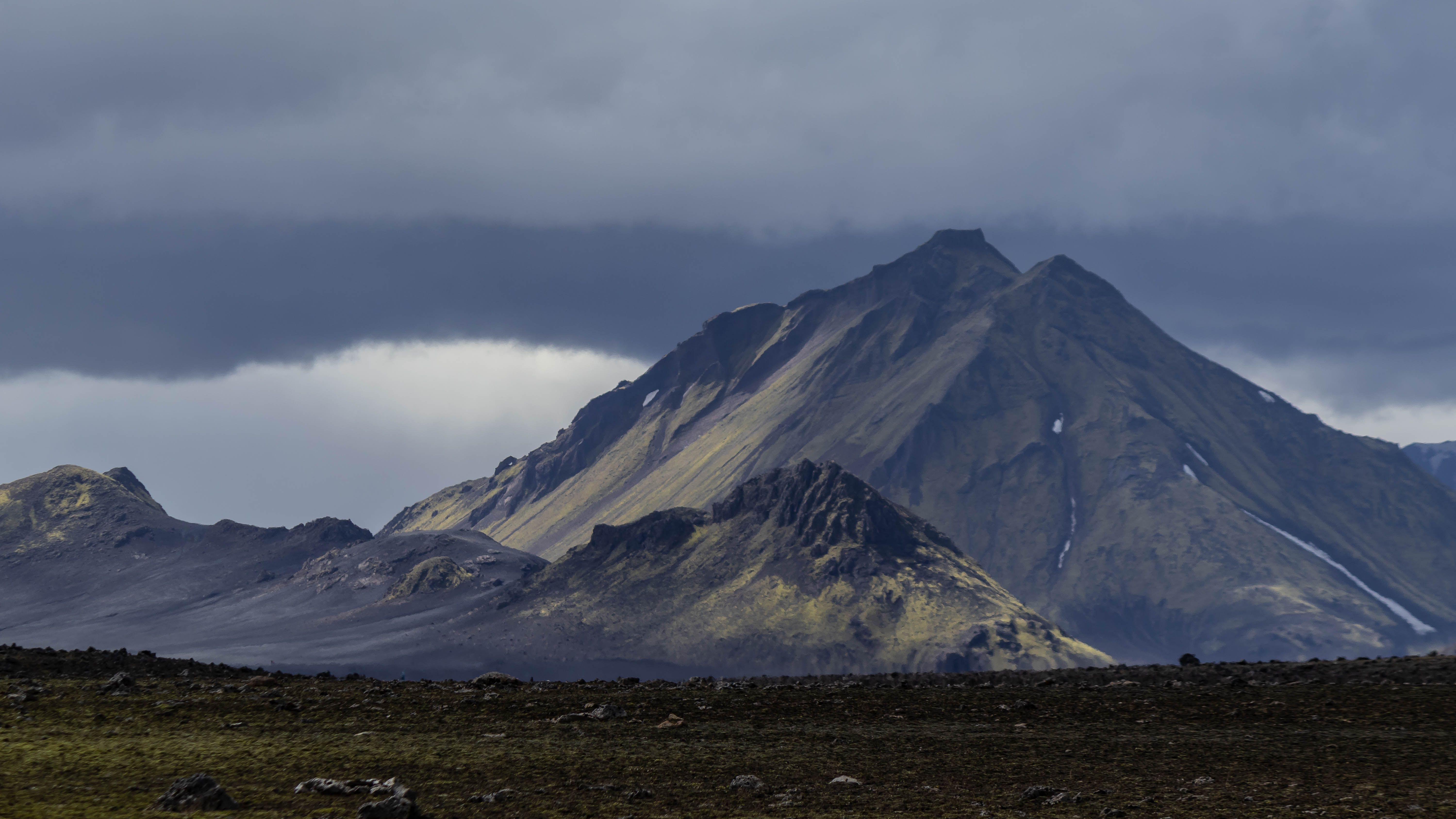Stunning view of Icelandic mountains under dramatic clouds, showcasing the rugged natural beauty. Stunning view of Icelandic mountains under dramatic clouds, showcasing the rugged natural beauty.