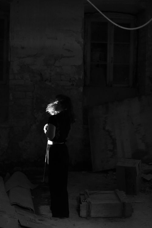 Free A mysterious silhouette of a woman in an abandoned room creates an eerie and dramatic atmosphere. Stock Photo