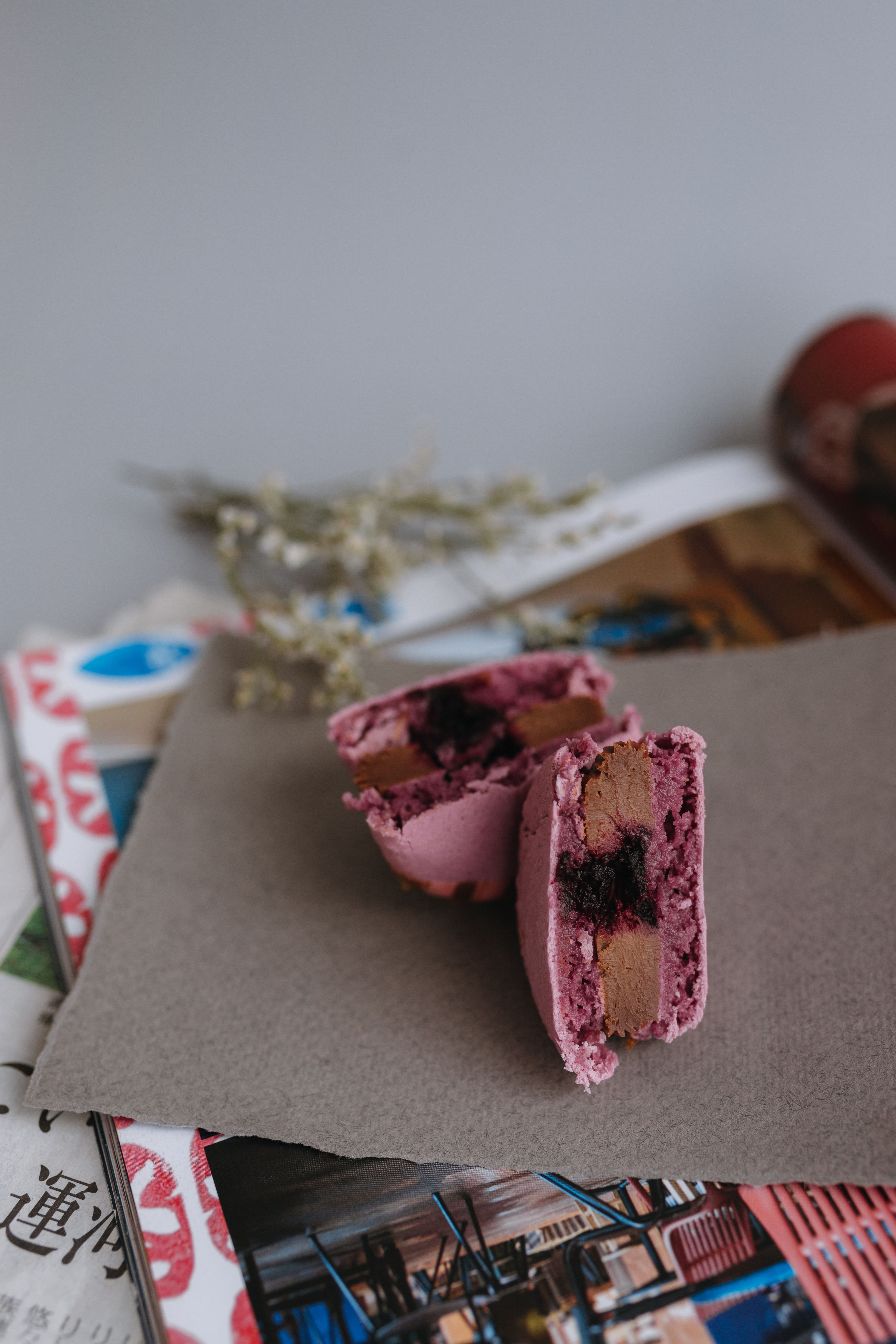 A pastry with a raspberry filling on top of a newspaper · Free Stock Photo