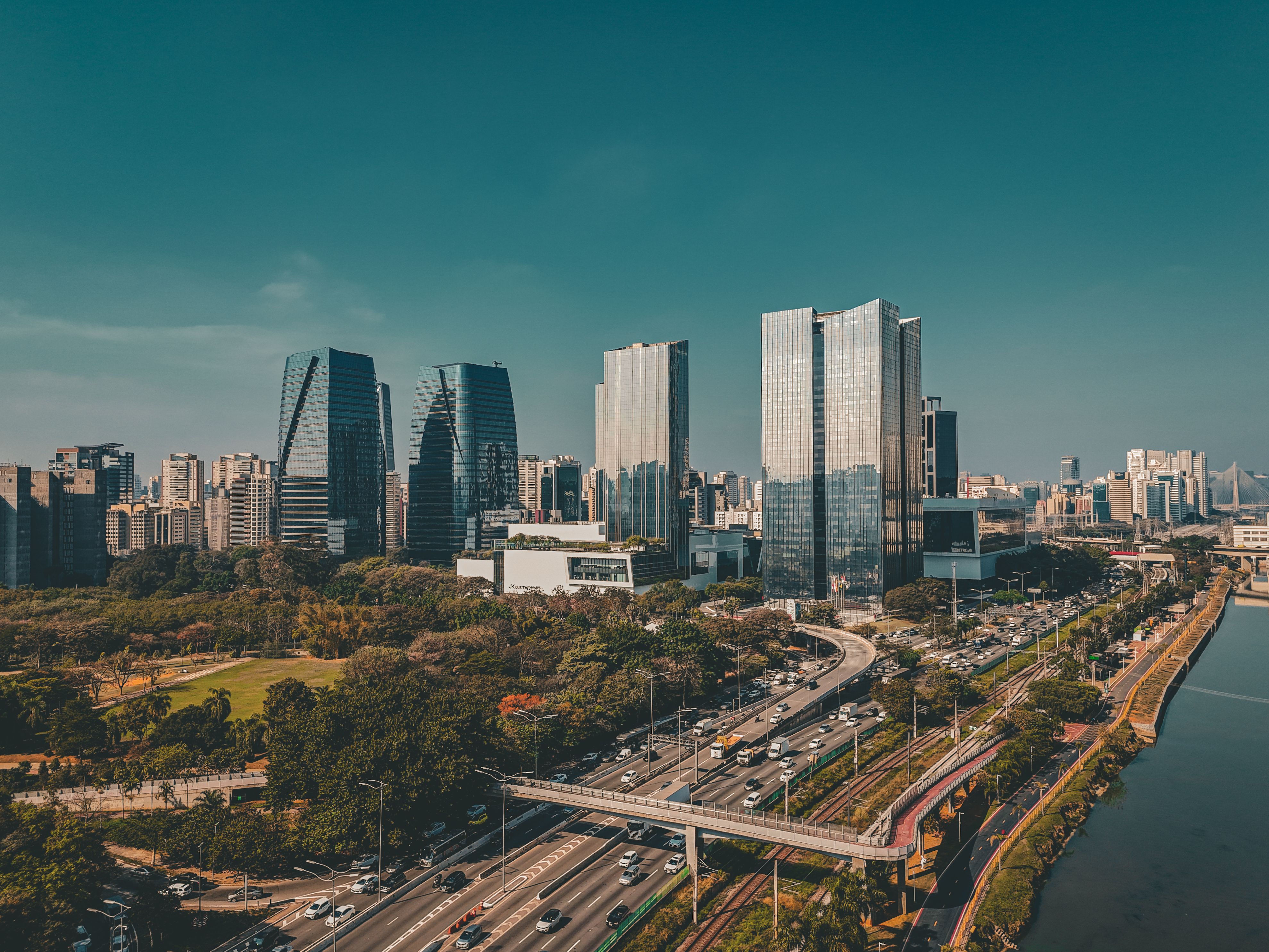 Explore the vibrant São Paulo skyline featuring modern skyscrapers, a bustling highway, and serene waterfront.