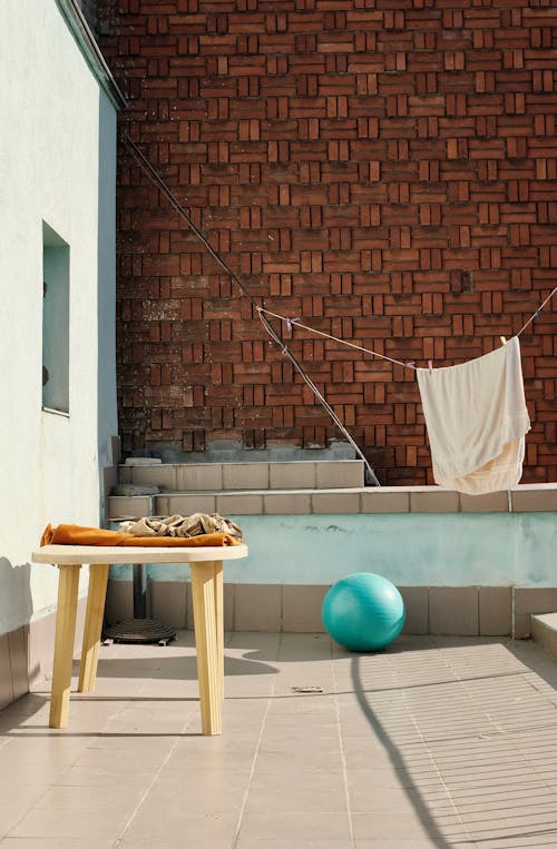 Wooden Table Next to Wall of Building