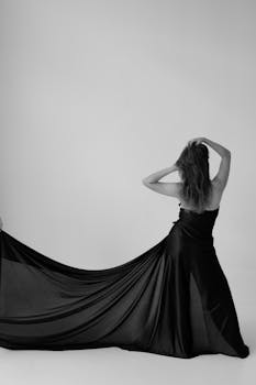 这张黑白照片拍的是一位穿着优雅长裙的女子背影