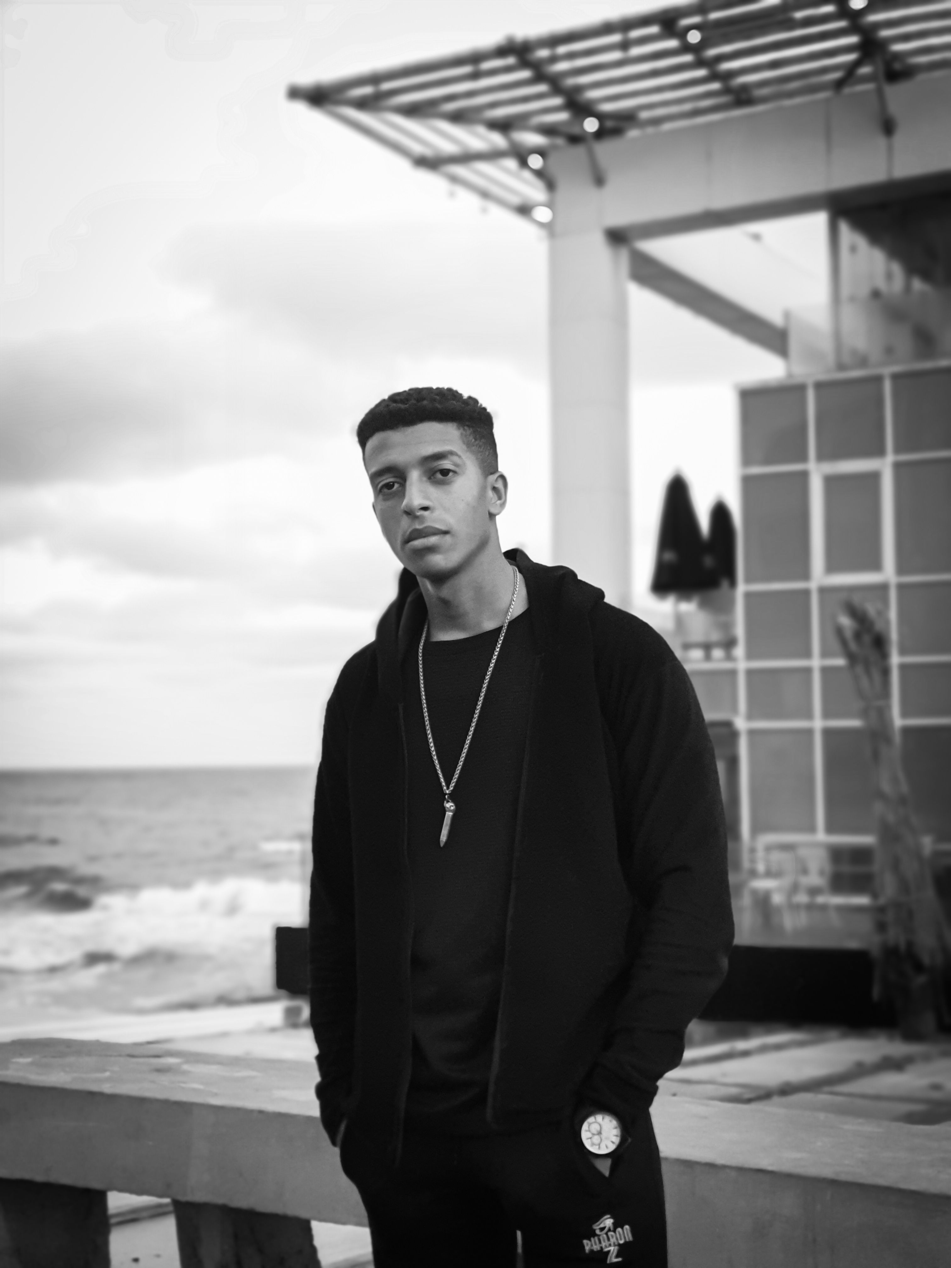 Black and white portrait of a man by the sea in Alexandria, Egypt.