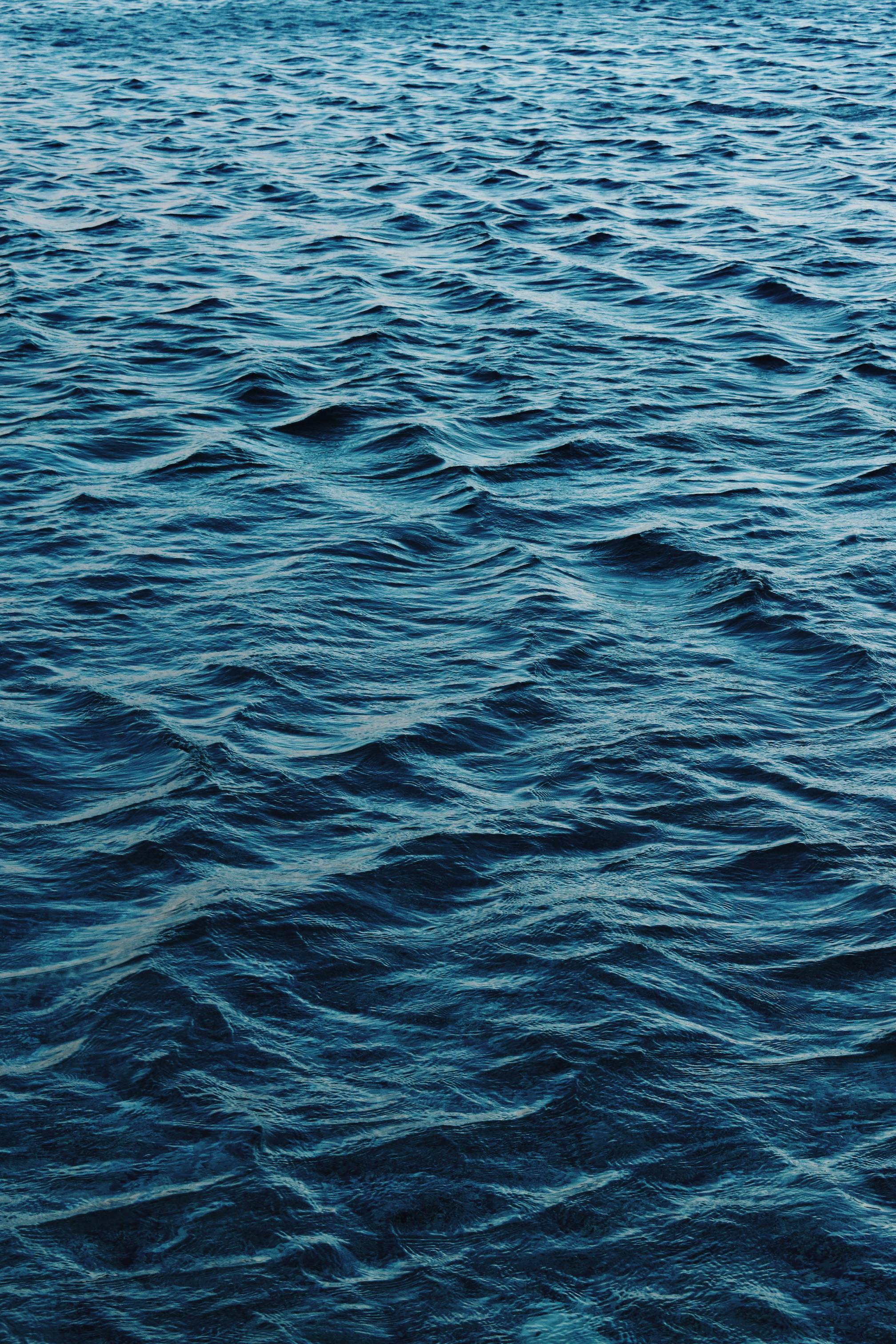 Tranquil deep blue ocean waves gently rippling, creating a soothing textured surface.