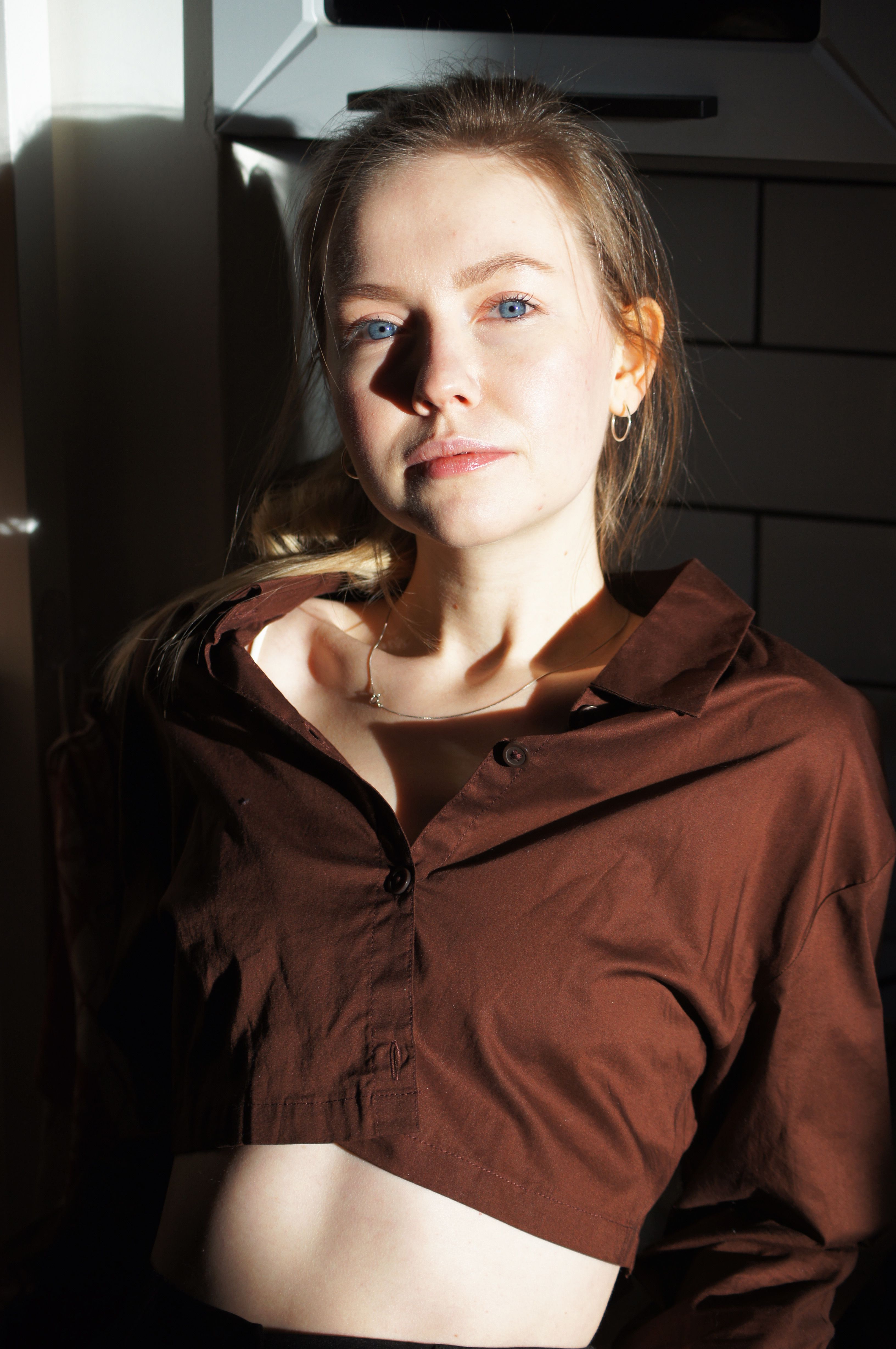 Elegant portrait of a woman indoors, showcasing high fashion style and natural lighting.