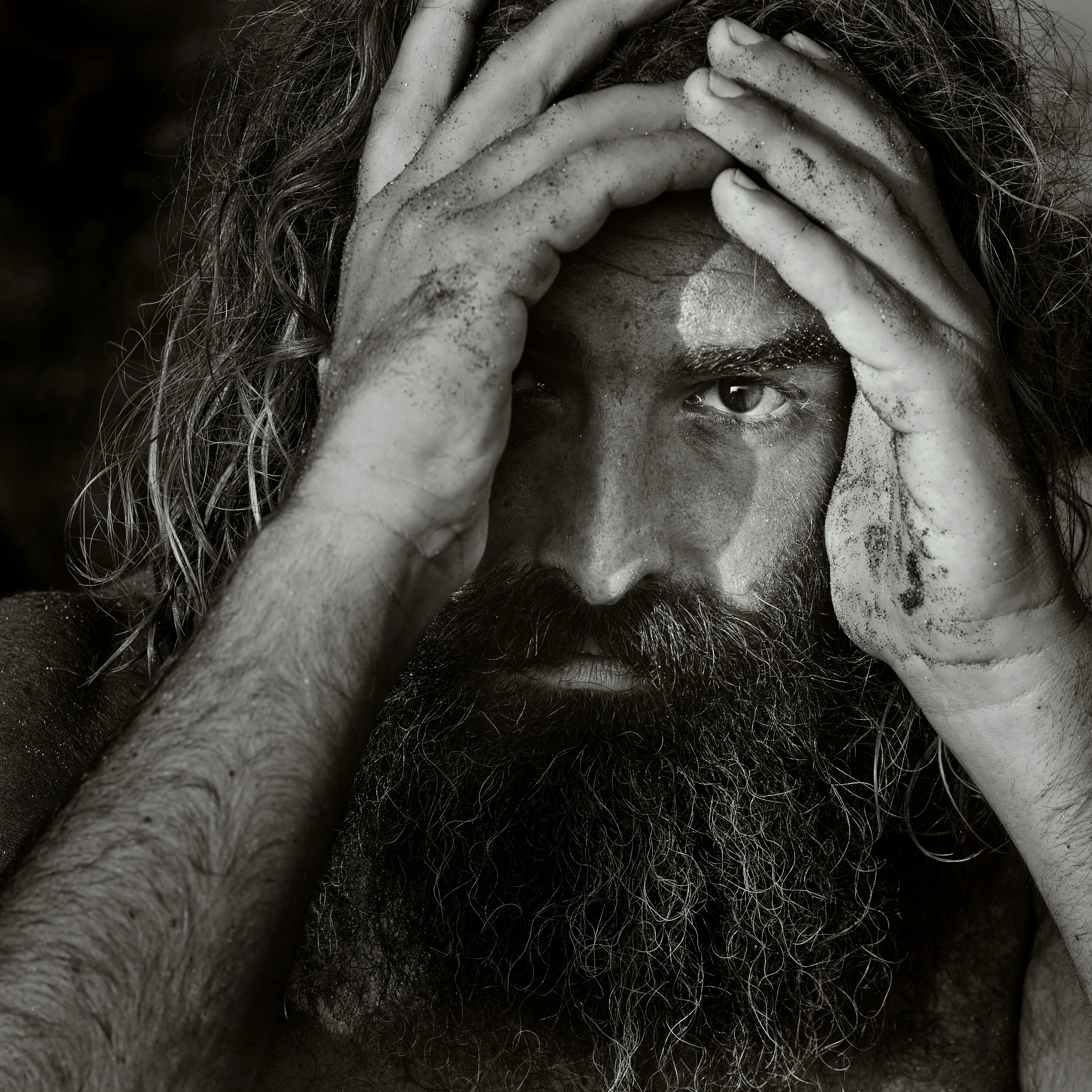 Black and white portrait of a bearded man with a contemplative expression.