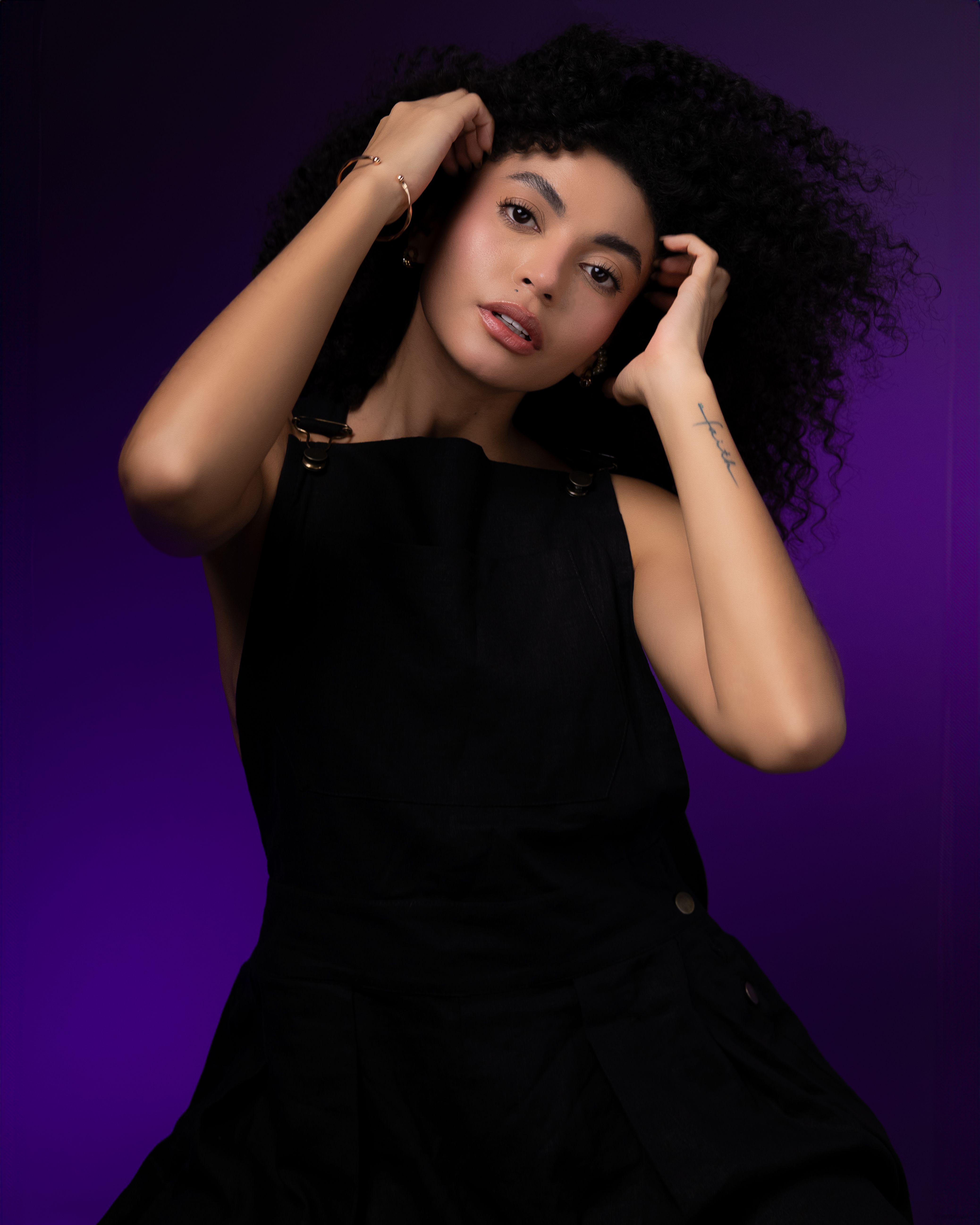 A woman with curly hair posing for a portrait · Free Stock Photo