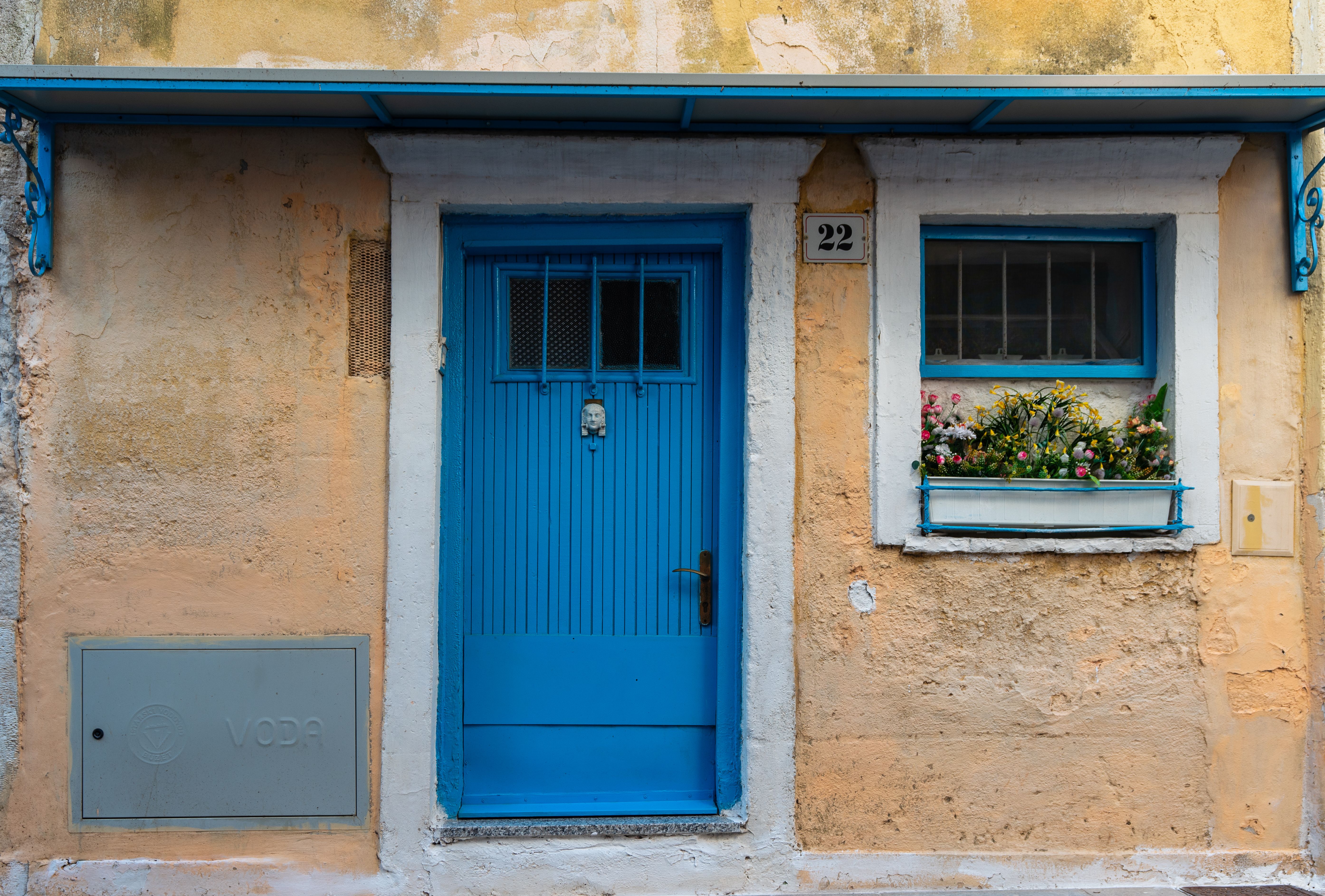 A blue door on a building with a window · Free Stock Photo