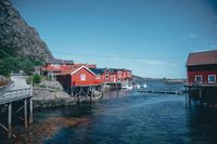 Red timber boathouses on a fjord, photo by Malte Luk on Pexels