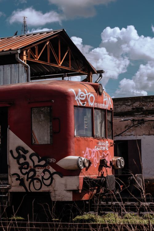 Free Rusty vintage train adorned with graffiti under a clear sky, capturing urban decay. Stock Photo