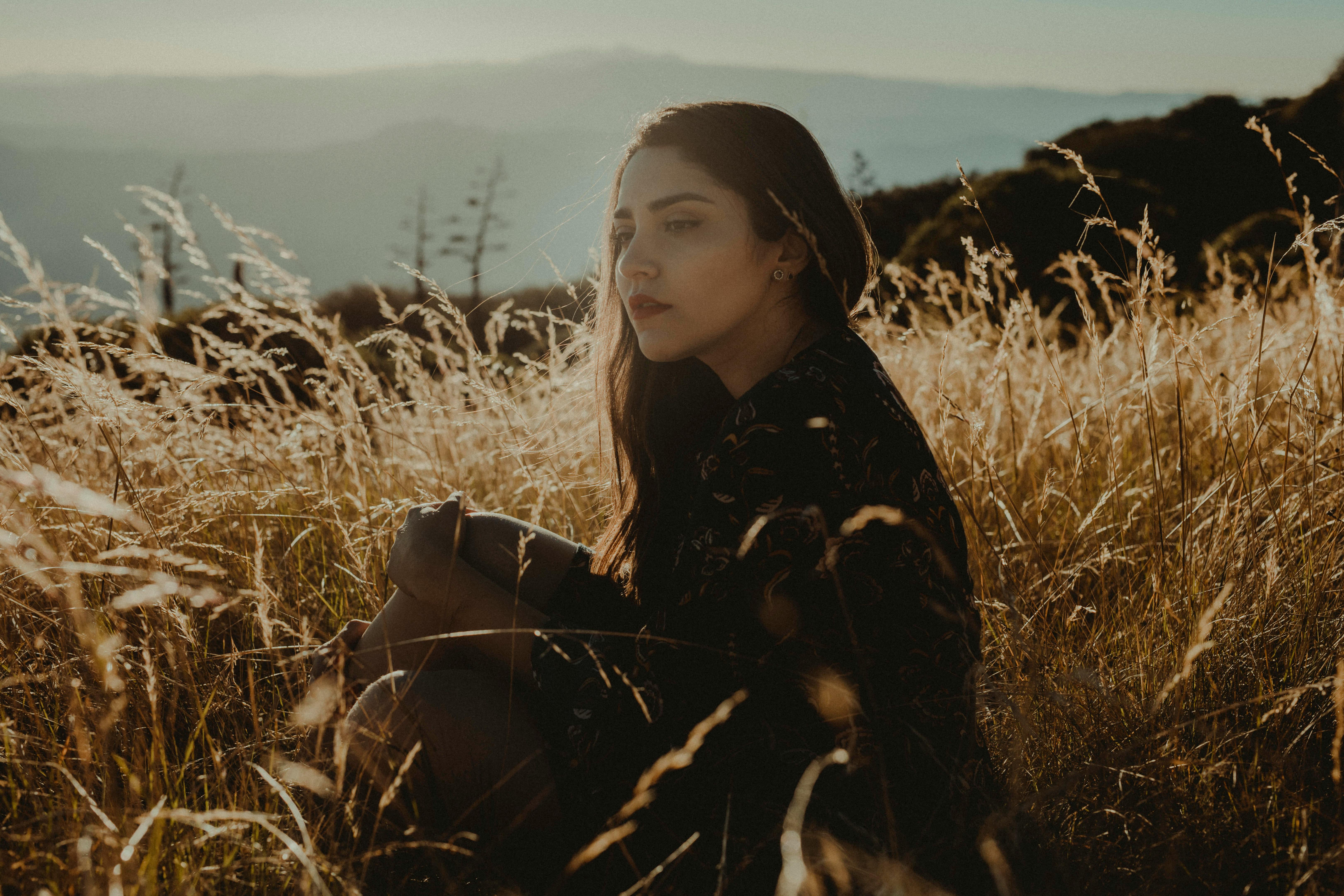 一个女人安静地坐在阳光明媚的草地上，享受着宁静的时光