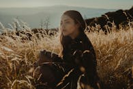 一个女人安静地坐在阳光明媚的草地上，享受着宁静的时光