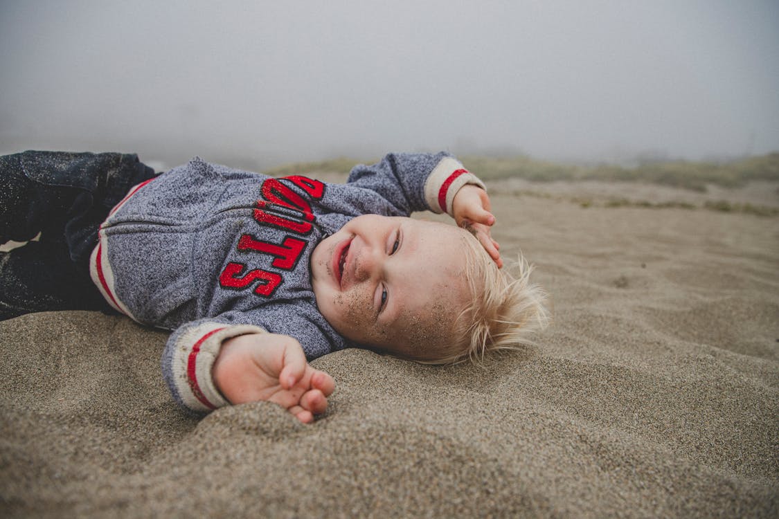 Free Photo of Boy Lying on Sand Stock Photo