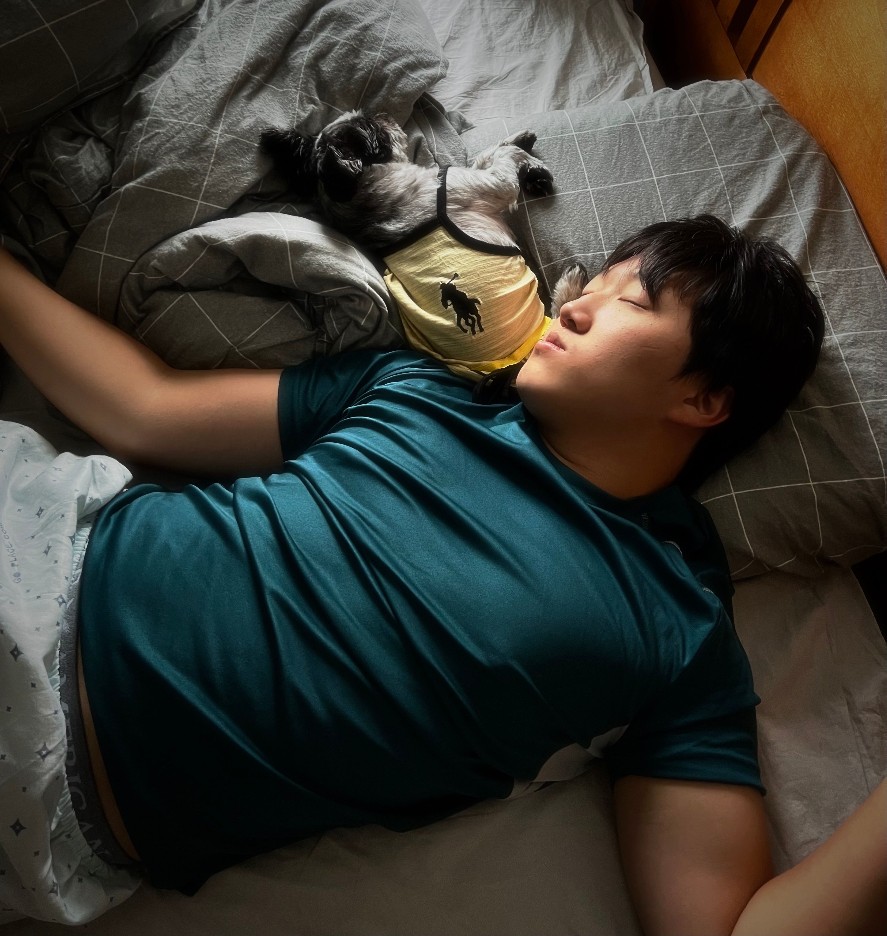 A peaceful scene of a man sleeping in bed with his dog in a cozy bedroom. Captured in Milton, ON.