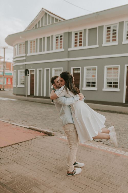 A couple hugging in front of a building · Free Stock Photo