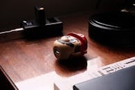 A toy iron man sitting on a desk next to a computer