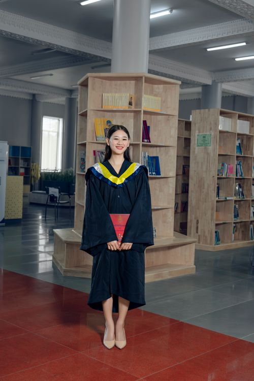 Library Graduation Photos A woman in a graduation gown standing in a library Β· Free Stock Photo
